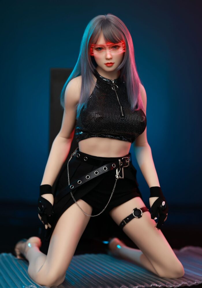 Briana Small Flat Chested Sex Doll With Colorful Hair, Red Glasses, And Edgy Outfit, Posed On A Dark Background For A Seductive Photo.