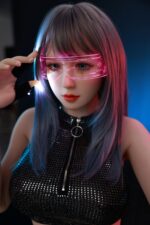Close-up of a realistic sex doll with purple and blue hair wearing pink futuristic glasses, in a dark setting.