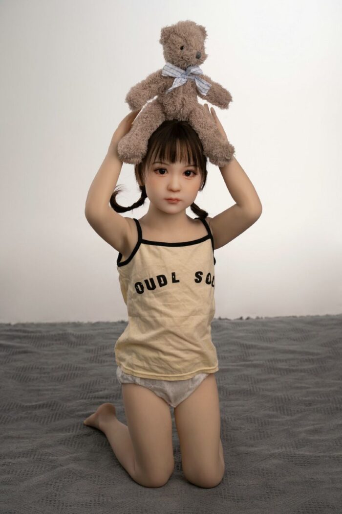 Cute Girl Holding Teddy Bear On Head, Soft Plush Toy, Adorable Kid With Short Hair And Tank Top, Playful Children Photography, Innocence And Childhood Joy.