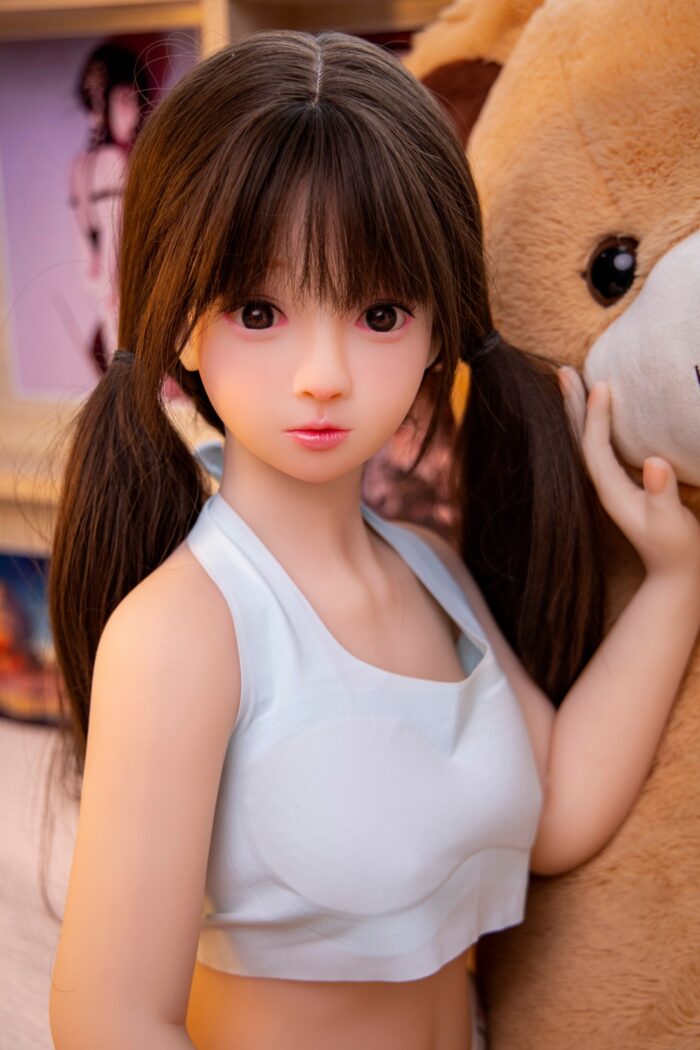 Silicone Sex Doll With Realistic Features, Girl With Brown Hair And Pigtails, In A White Tank Top Holding A Large Teddy Bear, Life-Size Adult Love Doll For Companionship And Intimacy, Perfect For Collectors And Enthusiasts.