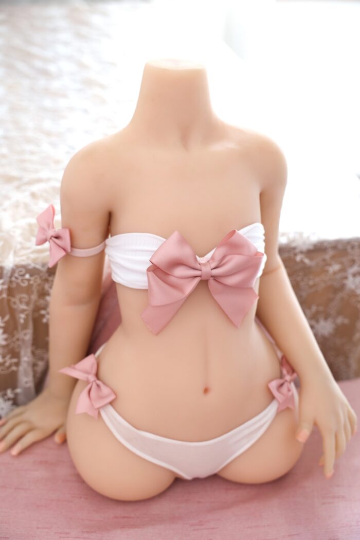 Realistic Soft Silicone Sex Doll With Pink Bows, Featuring A Petite Body And Lifelike Details, Perfect For Adult Companionship And Intimate Pleasure.