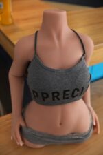 Flexibel, naturtroget sexdocksöverkropp med realistisk hudtextur, iklädd grå kläder, designad för intimitet och komfort, perfekt för personlig njutning och realistisk upplevelse.