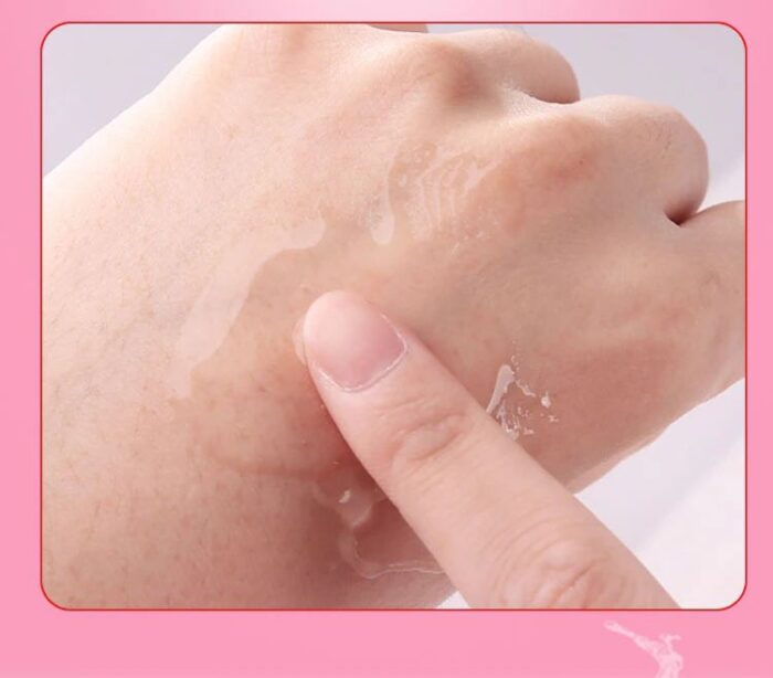 Demonstrasjon av fuktighetsgivende hudpleie på hånden, nærbilde av fingerpåføring av lotion, glatt hudtekstur med vanndråper, personlig pleie og hydreringskonsept, tips for sunn hud i rosa ramme.