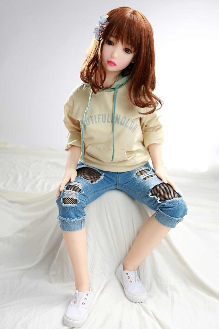 Realistic Sex Doll Girl In Casual Outfit With Ripped Jeans And Hoodie, Lifestyle Product, Bedroom Setting, Promotional Image For Sexdollmini.