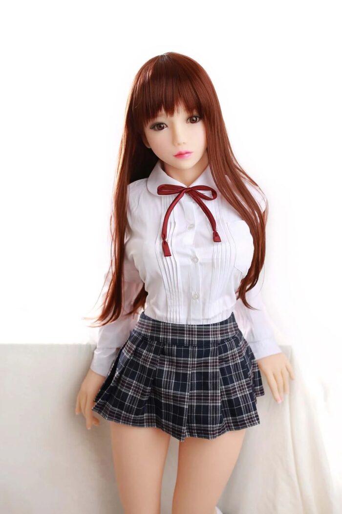 Silicone Sex Doll With Realistic Facial Features, Long Auburn Hair, Wearing A Schoolgirl Uniform With Plaid Skirt And White Blouse, Designed For Adult Pleasure And Companionship.