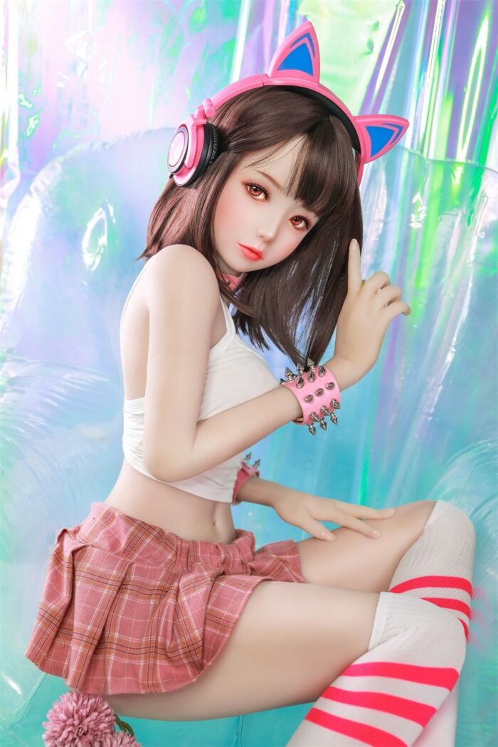 Silicone Sex Doll With Realistic Features Wearing Casual Schoolgirl Outfit, Pink Headphones With Cat Ears, And Colorful Background, Ideal For Adult Novelty Products.