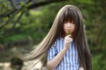 Realistic sex doll girl holding a leaf outdoors, natural setting, detailed features, high-quality silicone, perfect for adult companionship and collection.