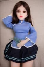 Silicone sex doll with realistic features, dressed in a blue traditional outfit, lying on a beige surface, designed for adult pleasure and companionship. Perfect for those seeking lifelike love dolls.