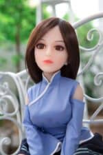 Realistic sex doll with lifelike features, brown hair, and blue outfit, designed for companionship and comfort. Perfect for those seeking intimacy with high-quality silicone dolls.
