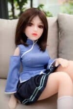 Doll sitting on sofa wearing blue school uniform, realistic sex doll, adult pleasure doll with brown hair and detailed facial features, perfect for companionship or intimate experiences.