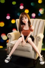 Realistic love doll sitting on a beige armchair with urban background, perfect for intimate companionship, high-quality sex doll for adult pleasure and realistic experience.