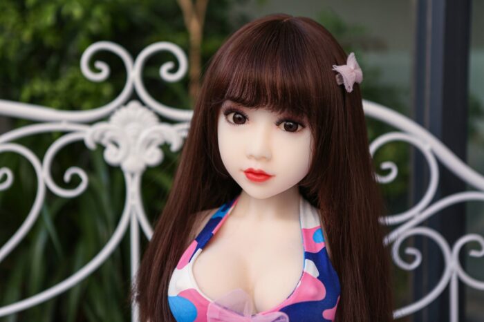 Realistic Sex Doll With Long Brown Hair, Lifelike Facial Features, And A Colorful Outfit, Designed For Companionship And Intimacy, Available At Sexdollmini For A High-Quality Experience.