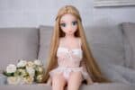 Handsome Sex Doll with Long Blonde Hair in Lacy Pink Outfit Sitting on Couch with Roses.