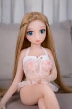 Silicone sex doll with blue eyes, long blonde hair, wearing a delicate pink lace lingerie top, sitting on a gray sofa, realistic features, ideal for adult novelty and companionship use.