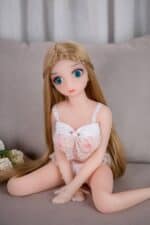 Realistic sex doll with blonde hair and blue eyes, dressed in lace lingerie, sitting on a gray sofa, designed for adult companionship and pleasure.