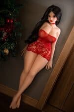 Realistic love doll with long black hair in red lingerie, posing next to a Christmas tree, designed for adult pleasure and companionship. Perfect for holiday gift ideas and intimate experiences.