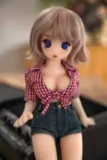 Miela anime stiliaus sekso lėlė didelėmis mėlynomis akimis, trumpais šviesiai rudais plaukais, vilkinti raudoną languotą palaidinę surištu audiniu ir džinsinius šortus, sukurta tikroviškam intymumui ir draugystei.