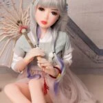 Silicone sex doll girl with silver hair and kimono, holding a parasol, posed indoors for realistic adult entertainment purposes.