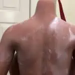 Moisturizing body lotion application on male chest and shoulders, emphasizing skincare and hydration for optimal skin health.
