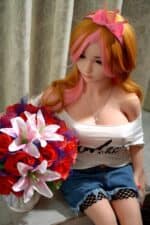 Silikon-Liebespuppe mit realistischen Gesichtszügen und langen rot-rosa Haaren, die ein lässiges schulterfreies Top und Netzstrümpfe trägt und einen Strauß leuchtender Rosen und Lilien hält.