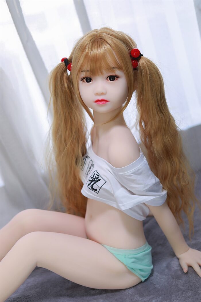 Arcadia Sex Doll14 Реалистичная секс-кукла с длинными каштановыми волосами и кукольными чертами лица, предназначенная для общения со взрослыми, размещаемая на мягкой поверхности в помещении.