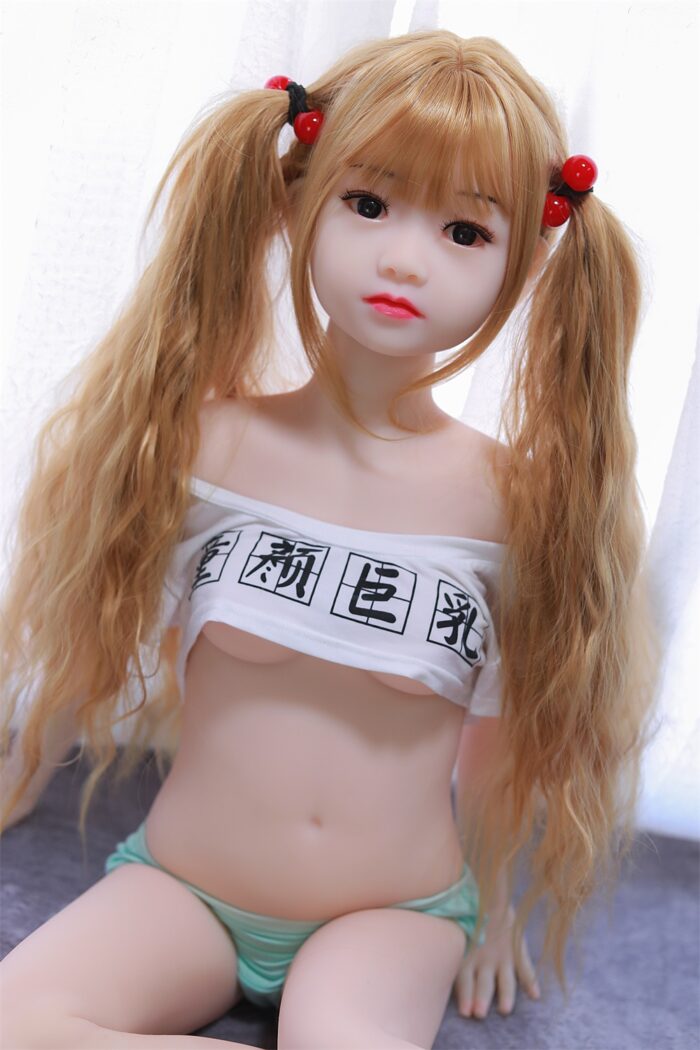 Arcadia Sex Doll4 Реалистичная секс-кукла с длинными светлыми волосами, уложенными в косички, одетая в белый топ с открытыми плечами с черными китайскими иероглифами и зеленое полосатое нижнее белье, предназначенная для интимного общения и терапевтических целей.
