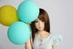 Silicone sex doll with balloons, realistic beauty, adult pleasure toy, miniature doll, headshot of beautiful sex doll for intimate companionship.