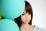 Realistic sex doll with lifelike facial features and brown hair, surrounded by pastel-colored balloons for a playful and appealing aesthetic. Perfect for those seeking authentic intimacy experiences.
