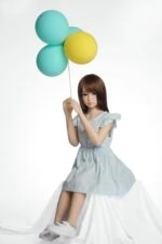 Soft silicone sex doll with realistic features holding colorful balloons, perfect for adult companionship and trendy visual aesthetics.