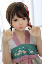 Realistisk silikone-kærlighedsdukke med anime-lignende træk, store øjne og kort brunt hår, iført en traditionel kimono med blomsterbroderi, der demonstrerer Sexdollminis produkters høje håndværksmæssige kvalitet.