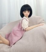 Realistic silicone sex doll girl lying on sofa with soft, detailed features and lifelike appearance, perfect for adult companionship, intimate pleasure, and discreet adult products.