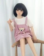 Soft-touched sex doll with realistic features, dressed in casual clothing and seated on a wooden chair for a natural, inviting pose. Perfect for adult toy shopping, emphasizing high-quality, lifelike design for intimate companionship.