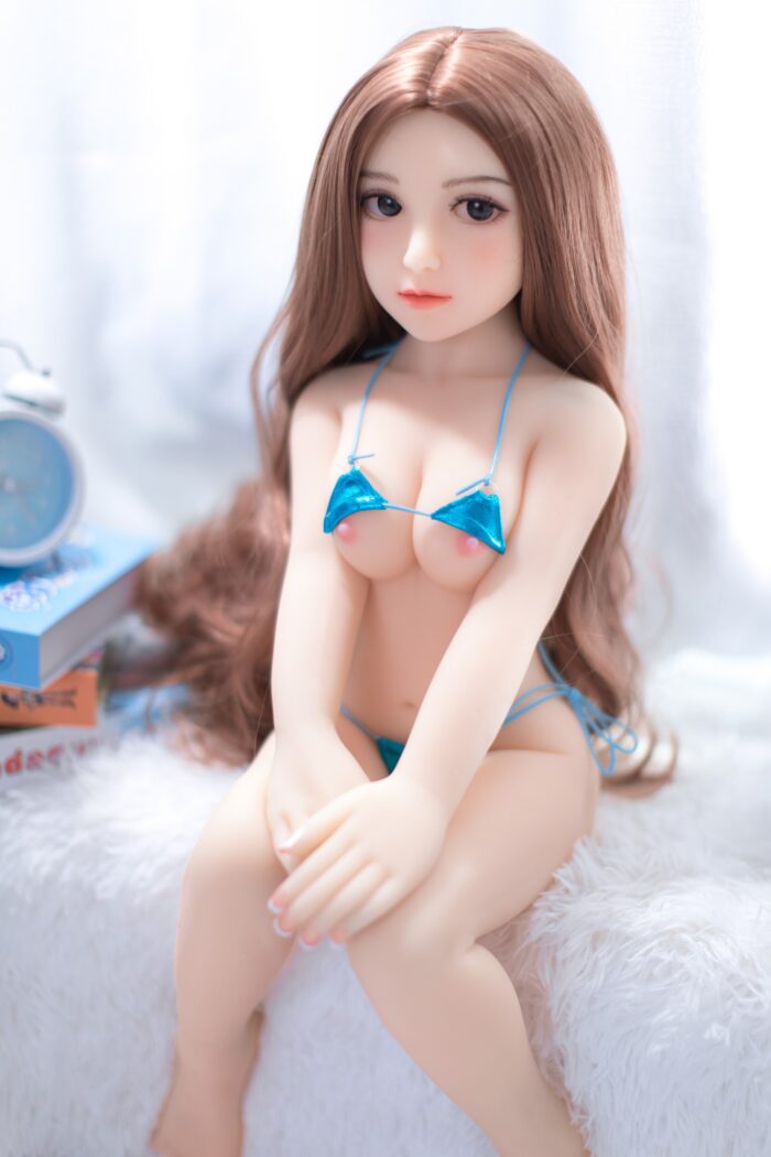 Realistic Sex Doll With Long Brown Hair In A Blue Bikini Top And Bottom, Sitting On A White Furry Surface, Designed For Intimate Companionship And Adult Entertainment, With Detailed Features And Realistic Appearance.